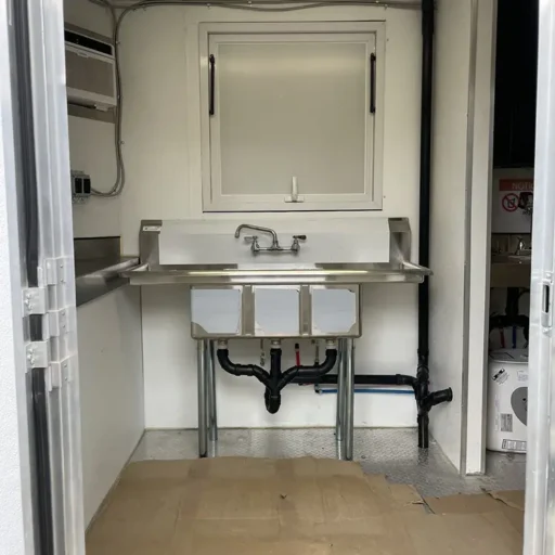 A compact kitchen featuring a sink, perfect for use in a food truck.